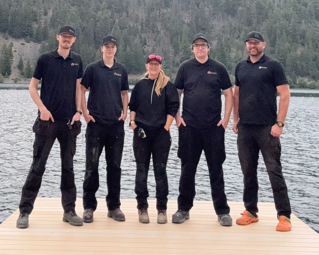 Five Taurus Electric team members in branded workwear standing on a dock.