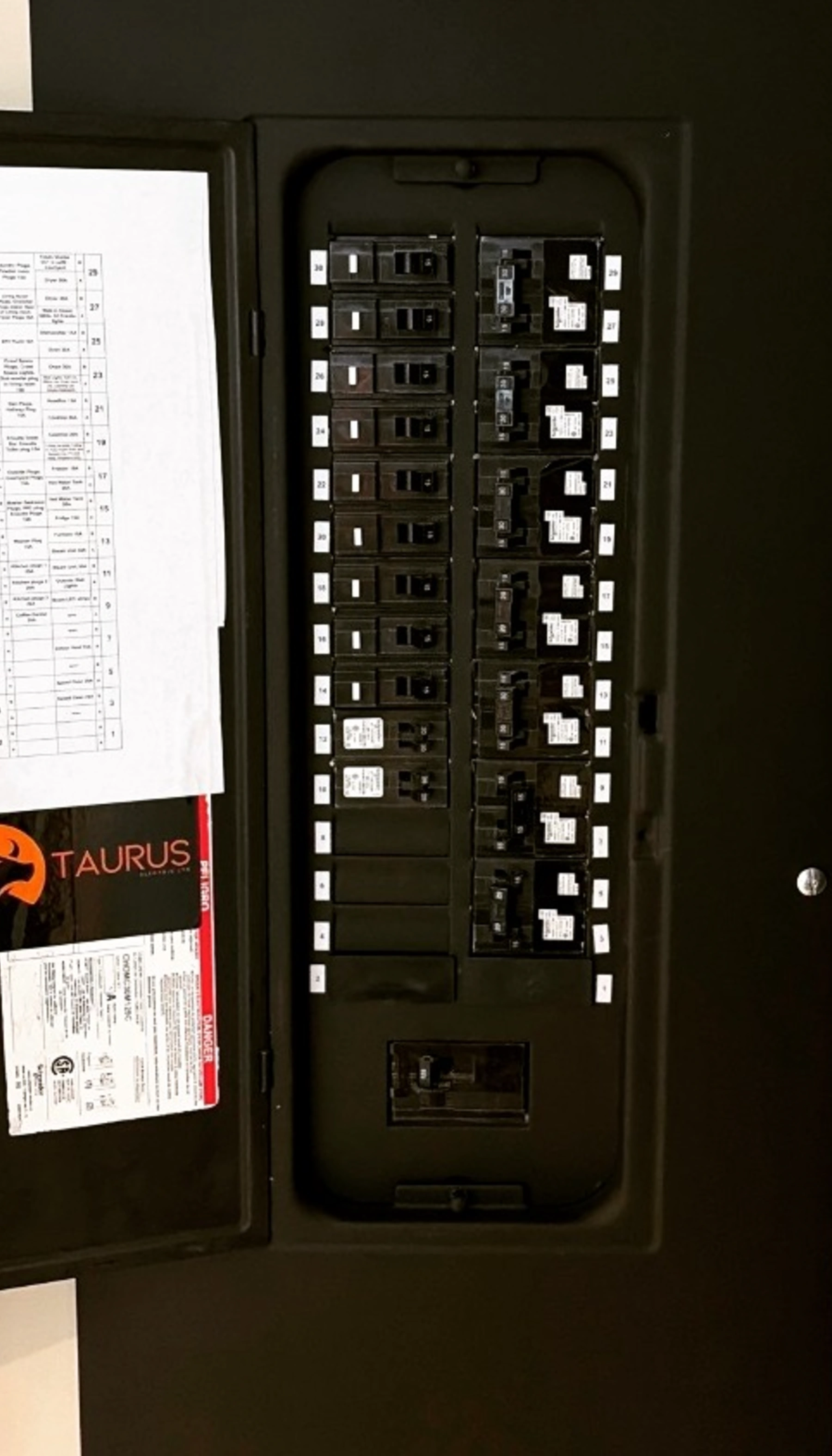 An open residential electrical panel in Abbotsford with neatly organized breakers, numbered circuit labels, a typed directory, and a Taurus Electric sticker on the door.