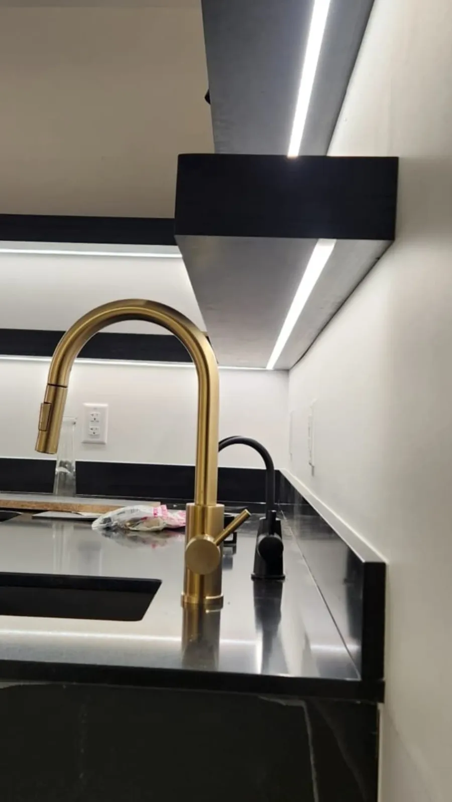 Linear LED strip lighting installed in a soffit above a finished counter, part of a commercial lighting upgrade in Abbotsford.
