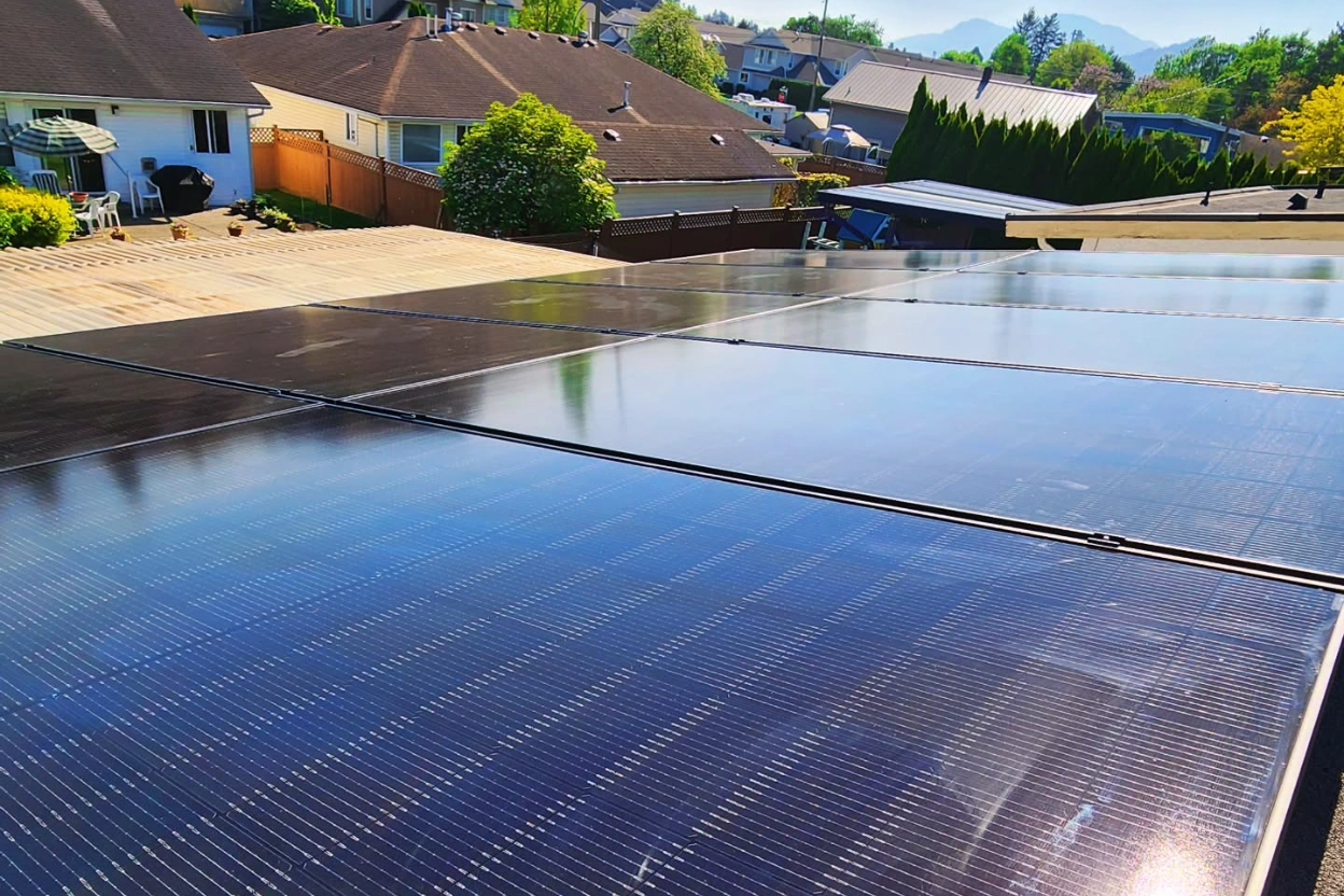 Rooftop solar panels on a Langley home, with neighbouring rooftops and the mountains beyond.