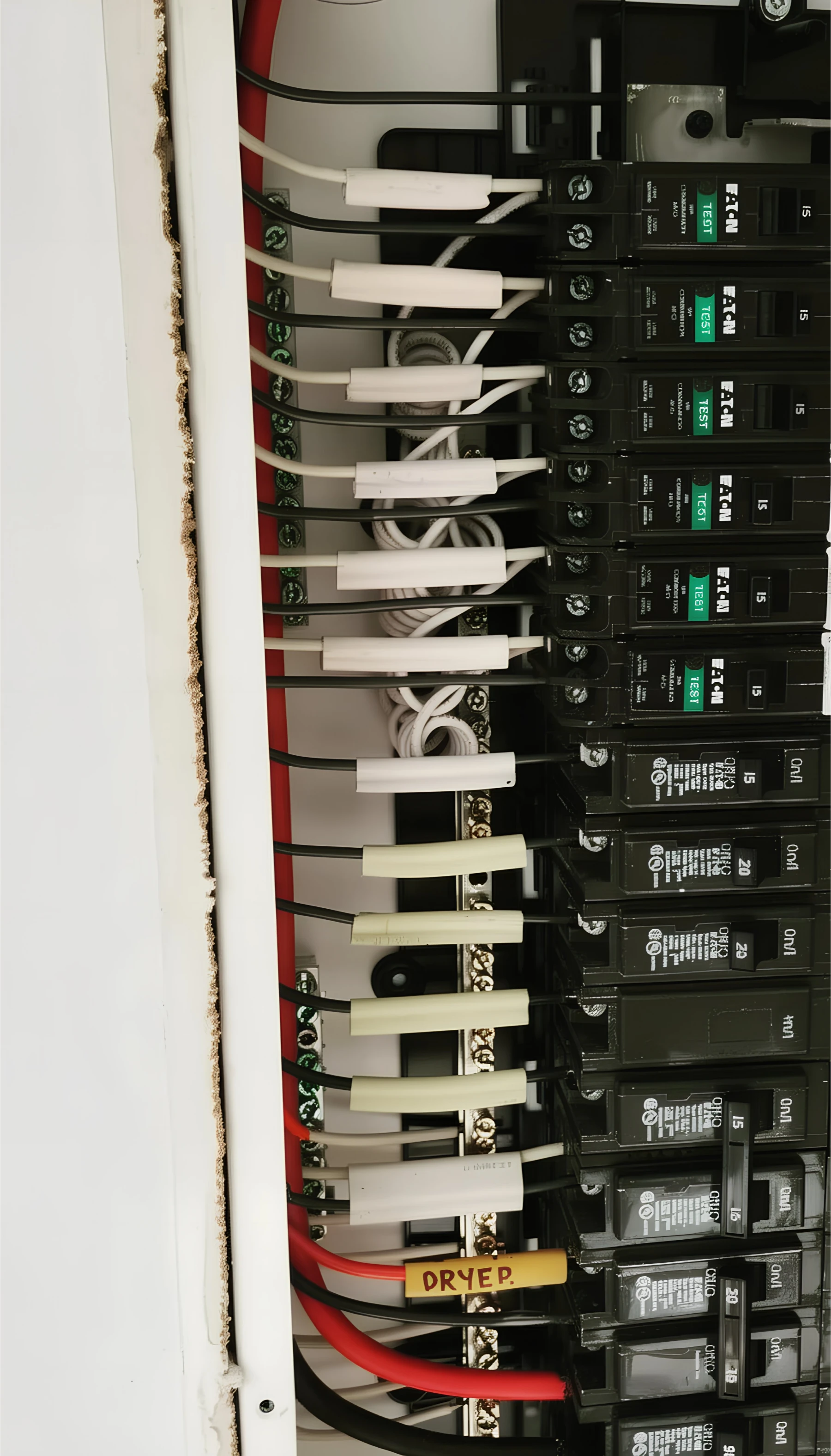 Electrical panel with multiple breakers, labeled circuits, and organized wiring, including a clearly marked "DRYER" breaker at the bottom.