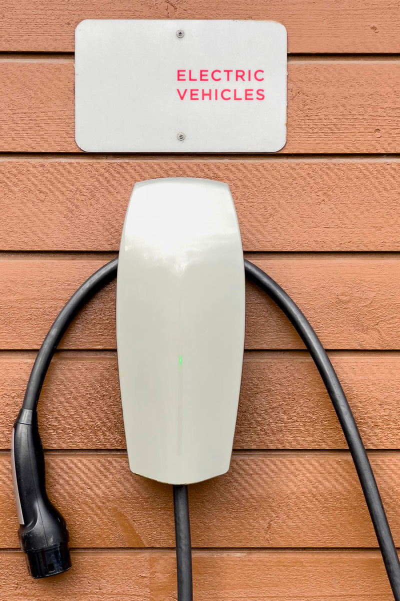 Electric vehicle charging station mounted on a wooden wall.