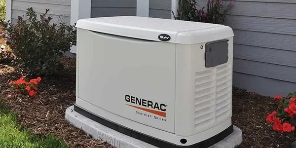 A Generac Guardian Series standby generator on a concrete pad outside a home.