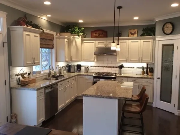 Modern kitchen with white cabinets, granite countertops and an island.